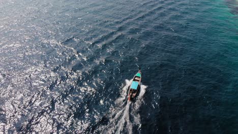 Ein-Kleines-Pumpboot,-Das-über-Die-Tiefblauen,-Grünen-Küstengewässer-In-Thailand-Fährt---Mavic-Drohnenaufnahme