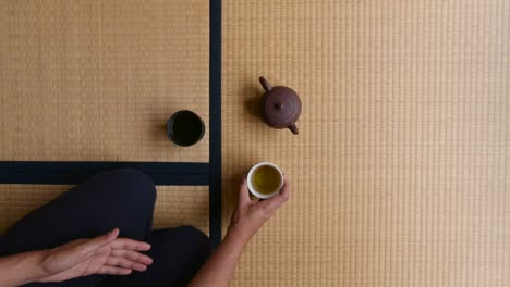 Mann,-Der-Japanischen-Traditionellen-Tee-Trinkt,-Während-Er-Auf-Tatami-Boden-Sitzt---Mittlerer-Schuss