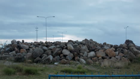 A-pile-of-rocks-on-a-grassy-field-at-the-Cadiz-City-New-Port,-Philippines