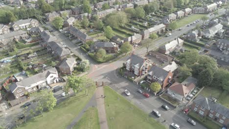 Drone-aerial-view-overlooking-British-town-houses-gardens-suburban-residential-overhead-scene-birds-eye-pan-left