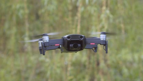 Mavic-Air-drone-slowly-flies-into-focus-and-stops-to-hover-in-place
