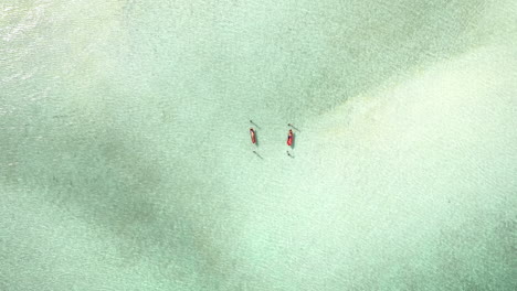 Two-people-relaxing-in-hammocks-in-the-clear-waters-of-Koh-Rong-Samloem,-Aerial-god-view