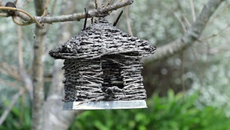 Wooden-bird-house-hanging-in-a-tree,-close-up