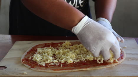 Chef-Agregando-Coberturas-A-Una-Base-De-Pizza-Antes-De-Ponerla-En-El-Horno