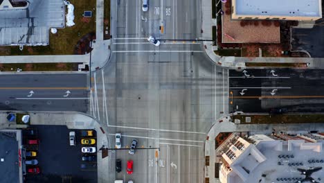 Bird's-eye-aerial-drone-top-view-of-a-busy-intersection-with-cars-passing-by-in-downtown-Provo,-UT