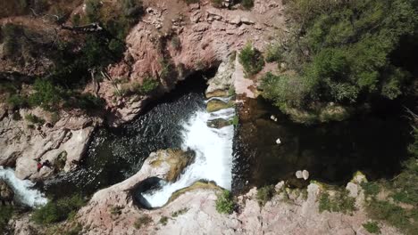 Fotografía-Aérea-De-La-Izquierda-Del-Carro-Sobre-La-Cascada-Y-La-Cueva-De-Fossil-Springs,-Arizona