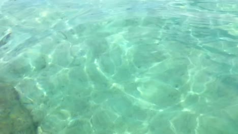 Slow-motion-of-bright-crystal-clear-translucent-and-transparent-sea-water-surface-with-white-sand-floor-and-ripples