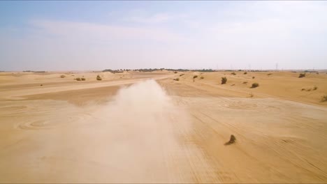 Black-4x4-truck-races-down-an-off-road-path-near-sand-dunes-in-the-desert-outside-of-Dubai,-UAE