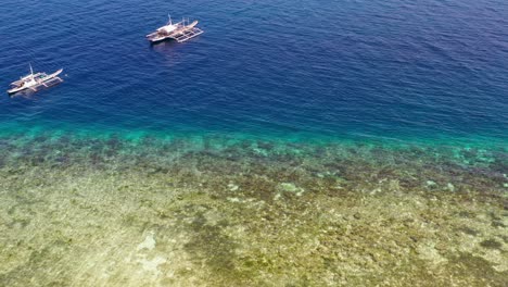 Playa-De-Filipinas-Con-Pesca-Tradicional-En-Catamarán-Y-Barcos-De-Buceo-Cerca-De-La-Costa,-Sobrevuelo-Aéreo-Revela-Disparo