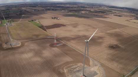 Aerial-View,-Two-Wind-Turbine-in-the-middle-of-a-farmers-field