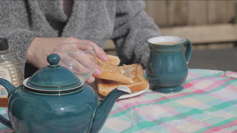 Person-enjoys-toast-in-traditional-English-breakfast-outdoors,-slow-mo