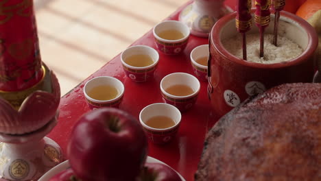 Traditional-red-Chinese-tea-cups-filled-for-ceremony,-close-up