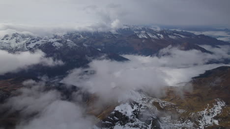Toma-Aérea-En-ángulo-Alto-Sobre-Montañas-Nevadas-Y-Nubes-De-Austria-Durante-El-Día
