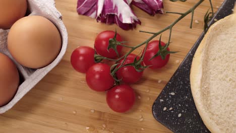 Zoomen-Sie-Aus-Frischen-Tomaten-Und-Verschiedenen-Zutaten-Heraus,-Während-Sie-Einen-Leckeren-Bio-Hamburger-Detail-Mittelschuss-Kochen