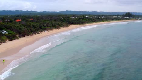 Hermosa-Playa-En-Byron-Bay---Océano-Azul-Brillante-Que-Rodea-La-Exuberante-Isla-Tropical-En-Nueva-Gales-Del-Sur,-Australia---Antena