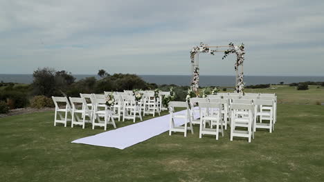 Wedding-ceremony-on-green-grass-with-white-carpet---flower-arch