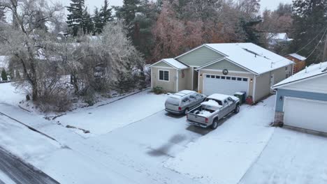 Orbiting-drone-shot-of-a-single-family-house-in-middle-class-America-covered-in-snow