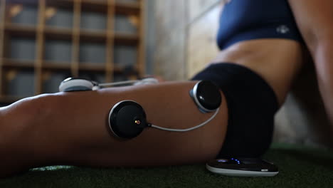 Nahaufnahmen-Von-Elektrovibrations-Massagepads,-Die-An-Den-Beinen-Eines-Athleten-Verwendet-Werden