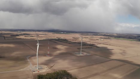 Two-wind-turbines-stand-tall-in-the-middle-of-farmers-fields