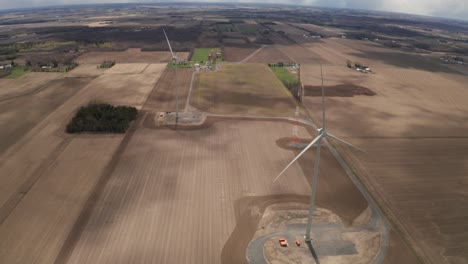 Wide-shot-of-two-wind-turbines-slowly-moving-in-the-wind
