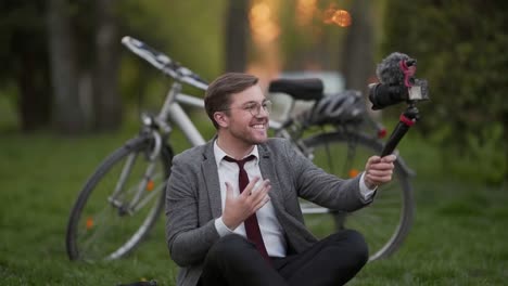 handsome-young-businessman-shooting-himself-holding-a-tripod-camera-in-his-hands