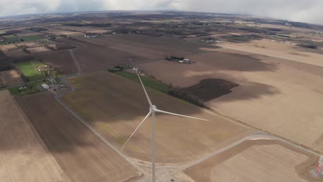 Slow-tilt-up-revealing-vast-farmlands-around-a-wind-turbine