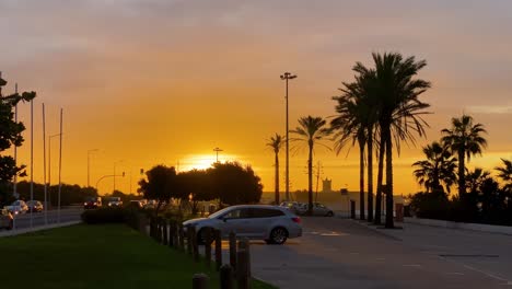 Silhouette-shot-of-the-fort-and-some-plams-in-parking-car-near-the-beach-Carcavelos-with-sunrise-sun
