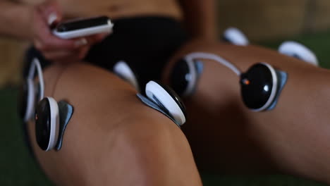 close-up-footage-of-electro-vibration-massage-pads-being-used-on-an-athletes-legs