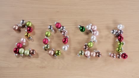 new-year-twenty-twenty-one-written-with-Christmas-balls,-sharp-to-out-of-focus