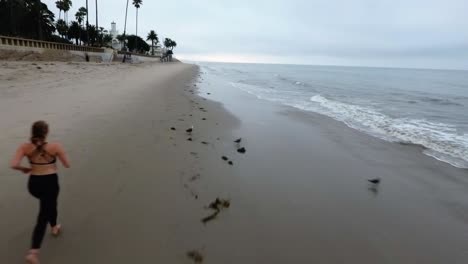 Woman-Running-on-Beautiful-Beach-Located-in-Santa-Barbara-California