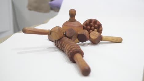 Close-up-of-a-wooden-massager-set-used-for-manual-deep-tissue-massage-therapy-laid-out-on-a-massage-bed-table-in-a-physiotherapy-clinic