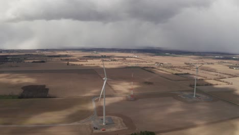 Aerial-view-of-two-large-wind-turbines-in-the-middle-of-farmlands