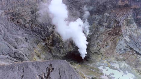 White-smoke-coming-from-vent-in-crater-of-active-volcano-on-White-Island,-aerial