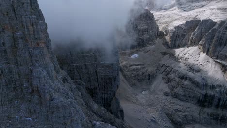 Luftvorwärtsflug-Entlang-Felsiger-Berge-Mit-Schwebenden-Wolken-In-Italienischen-Dolomiten