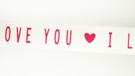 Moving-tape-with-the-inscription-I-love-you-Filmed-on-a-white-background