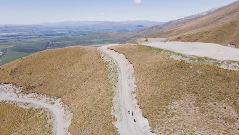 hikers-scaling-up-alpine-dirt-road-in-sunny-conditions