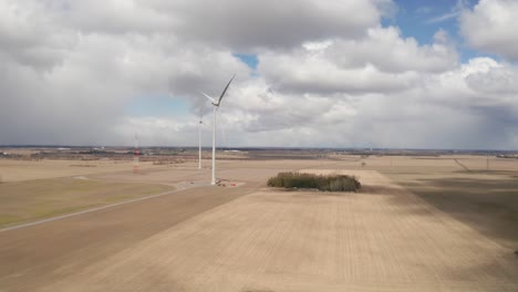 Two-large-wind-turbines-sit-idly-in-the-middle-of-farm-lands