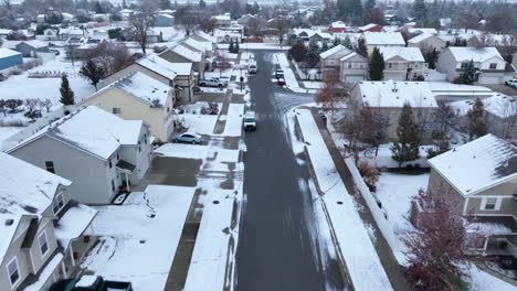 Low-aerial-flying-through-a-suburban-neighborhood-covered-in-snow