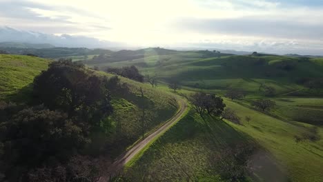 Aerial-View-Drone-Flying-Over-Green-Rolling-Hills-on-a-Sunny-Day