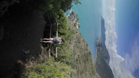 Vertical-Shot-Of-A-Female-Traveler-With-Backpack-Hiking-On-The-Amalfi-Coast-In-Summer-In-Italy
