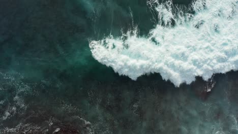 Beautiful-aerial-top-down-view-of-clear-turquoise-blue-ocean-water-covering-reef-rocks