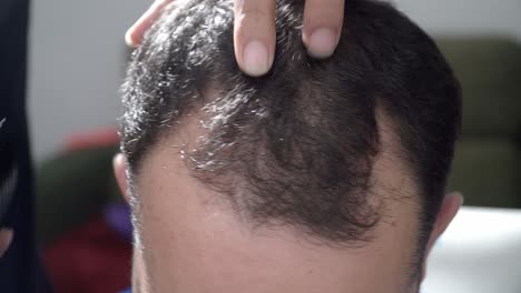 Close-up-shot-of-Trendy-barber-cuts-man's-hair-in-barbershop