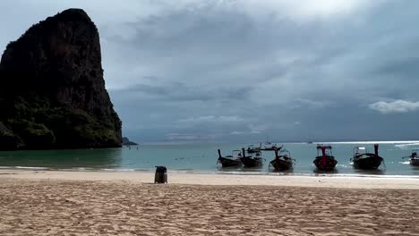 Man-Went-Back-To-Get-His-Luggage-On-The-Beach-With-Longboats-In-Koh-Phi-Phi-Island,-Thailand