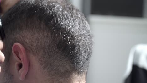Close-up-shot-of-Trendy-barber-cuts-man's-hair-in-barbershop