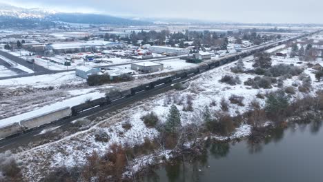 Drone-shot-of-a-train-traveling-through-snowy-conditions-in-Eastern-Washington