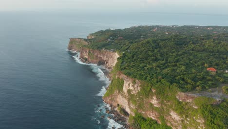 Aerial-drone-view-of-tall-sea-side-cliffs-covered-with-green-forest