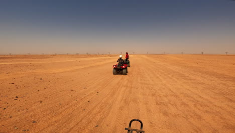 First-person-view-of-a-safari-on-quad-bikes-speeding-off-road-in-the-desert,-in-Hurghada,-Egypt