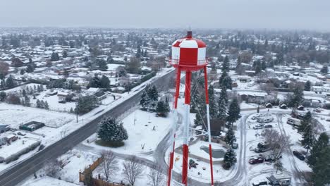 Aerial-view-of-a-water-tower-standing-high-above-the-snow-covered-ground