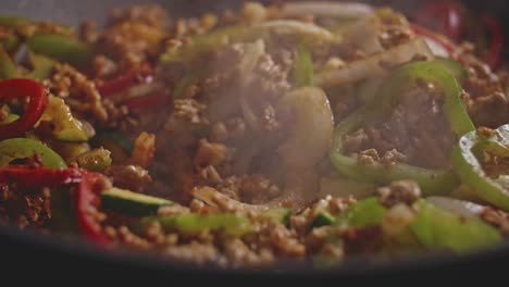 Macro-shot-of-meat-and-vegetables-in-a-wok,-cooking-homemade-mexican-food