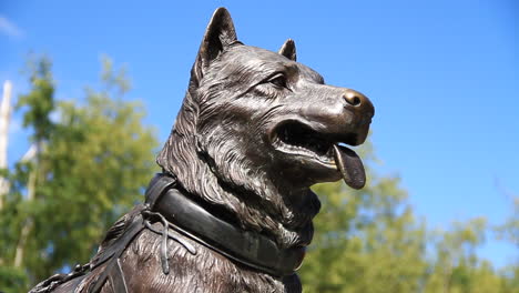 Iditarod-Dog-Statue-in-Alaska-with-Bug-Flying-by-in-Background